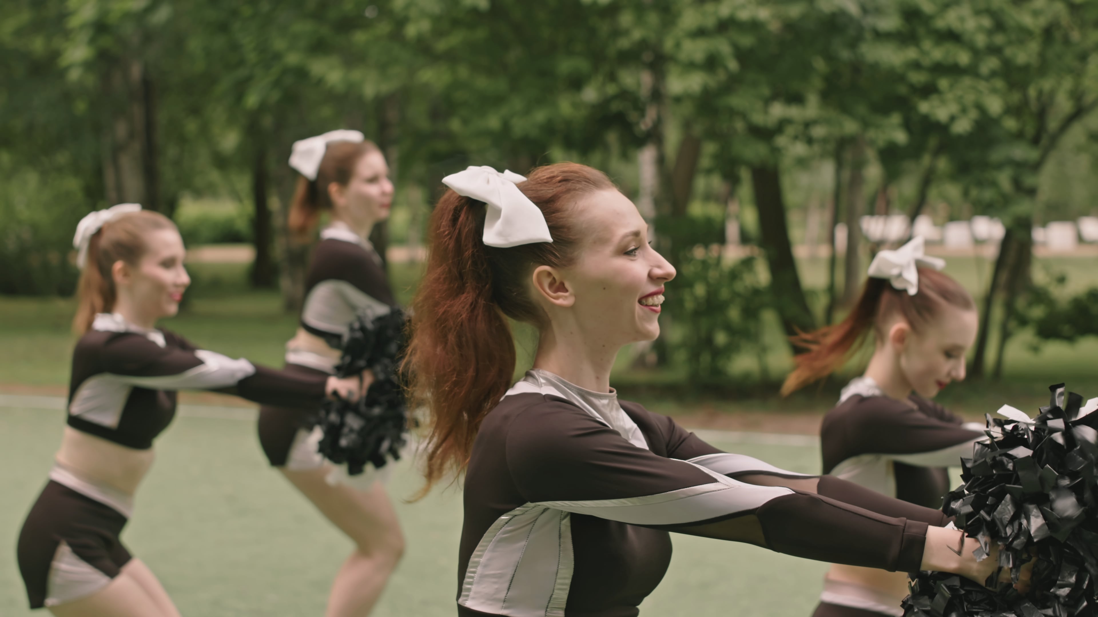 Cheerleaders smiling while practicing their routine